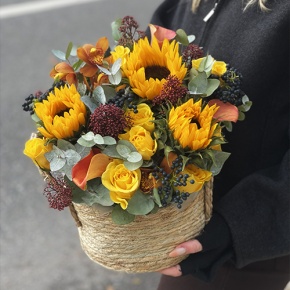 Композиция в сумке "Тональность" из подсолнухов, калл, ягод вибирнума, лимонных роз, скиммии и орхидеи в Фрязино